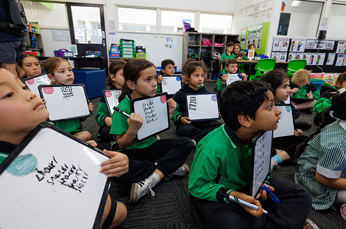 Students writing on whiteboards