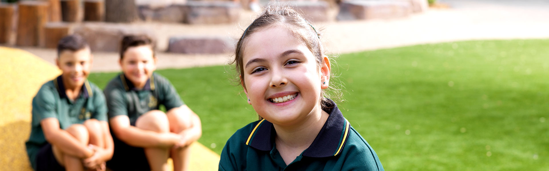 Smiling girl with 2 other students in the background