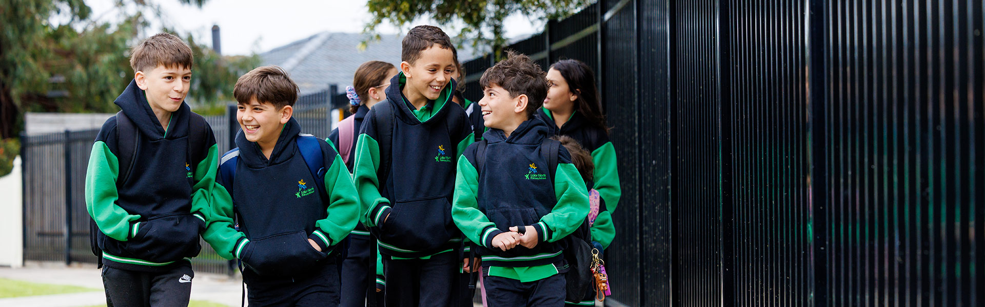 Smiling children in Lalor North Primary School Uniforms talking as they walk